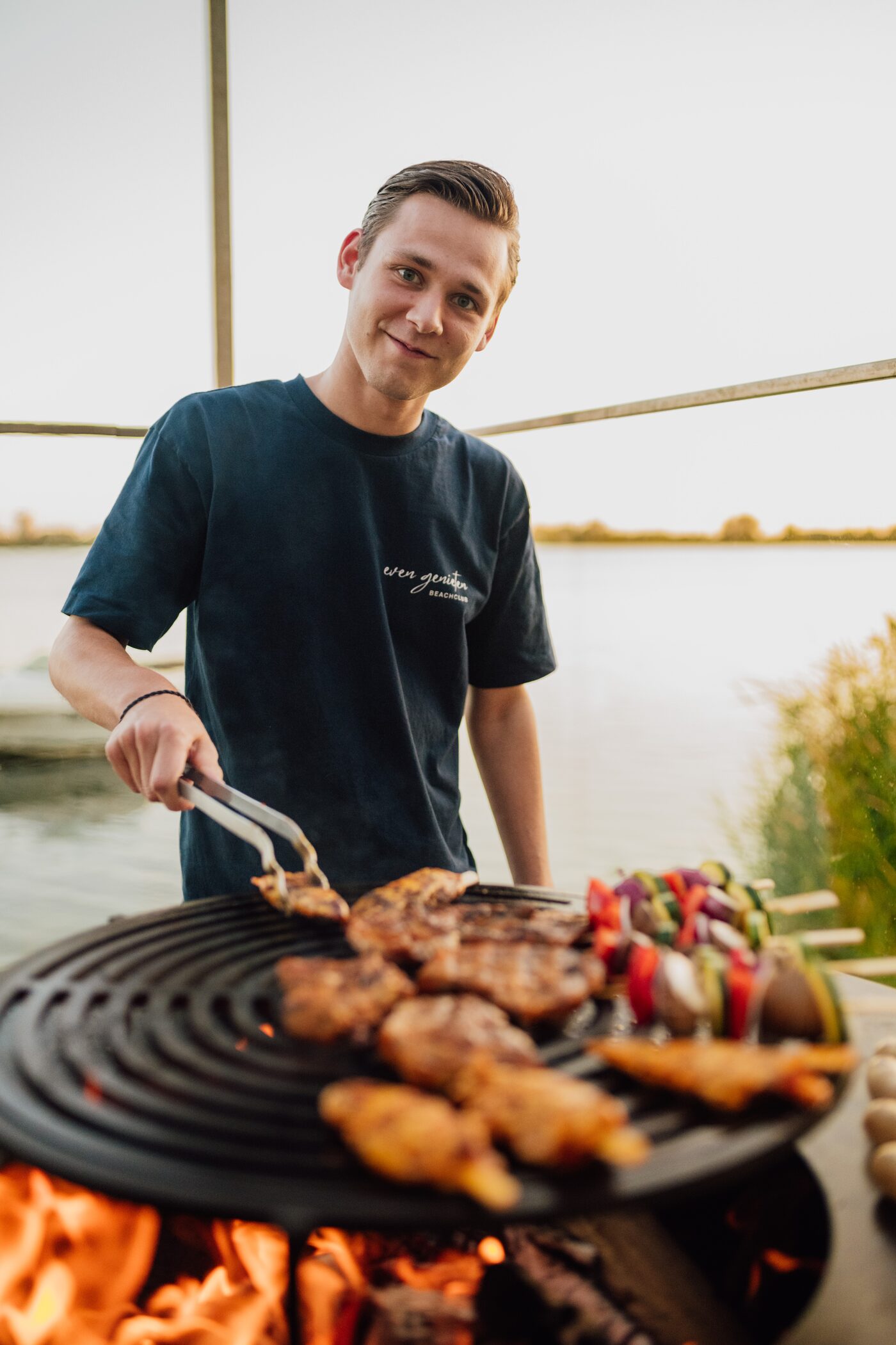Grillabend am Wasser, Beachclub-Team am BBQ-Ring bei Sonnenuntergang